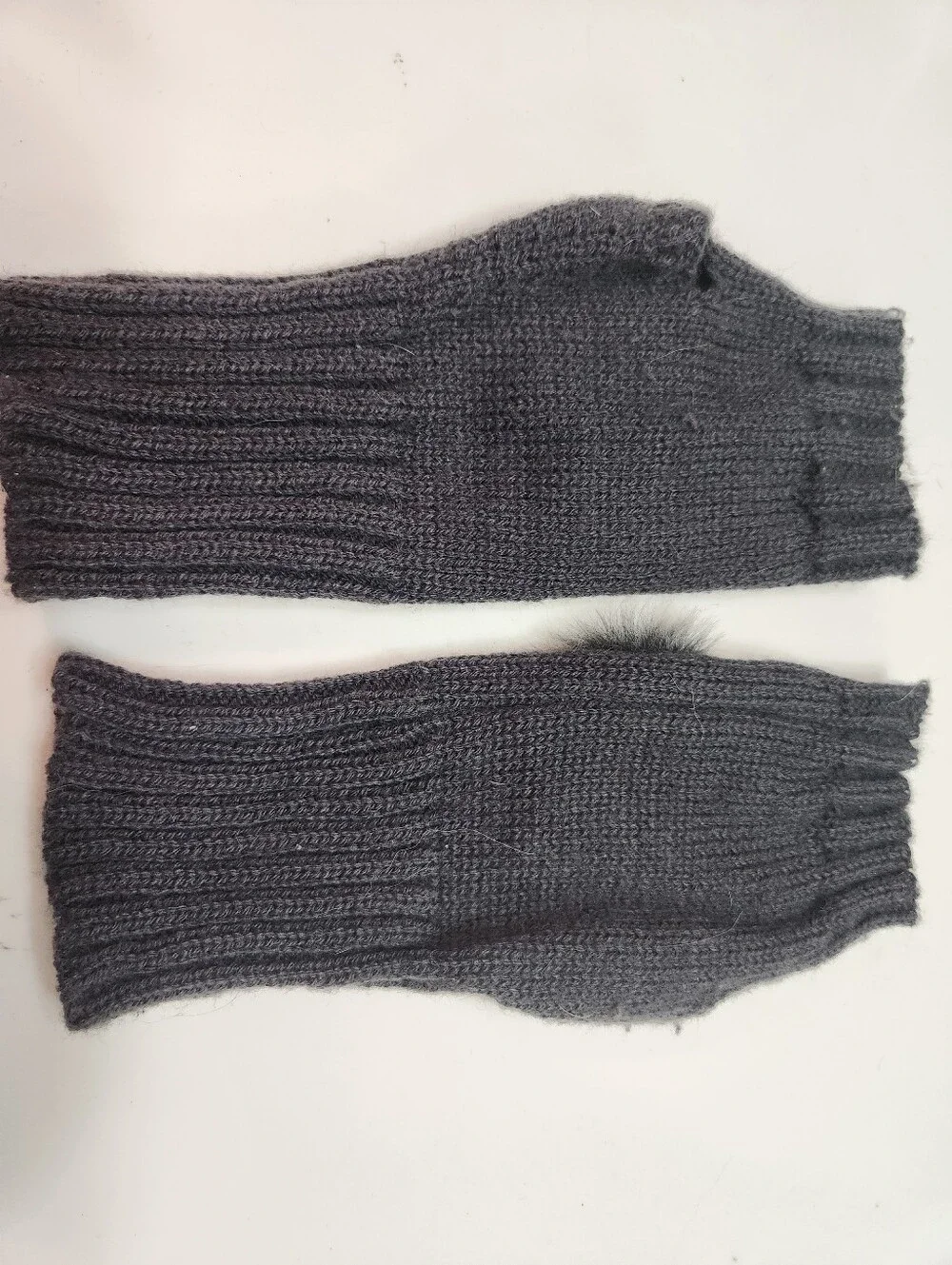 Dark gray women's winter fingerless knit gloves featuring a ribbed texture